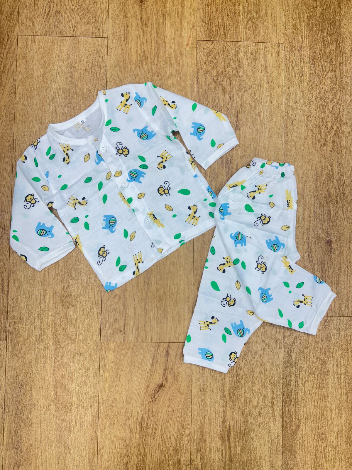 The image displays a white baby sleepsuit or pajama set, often describ ...