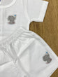 The item in the image is an (Magic train)Unisex Cotton Plain Baby Short Sleeves Suit & Short Pants. The small logo on both the shirt and shorts is a elephant.